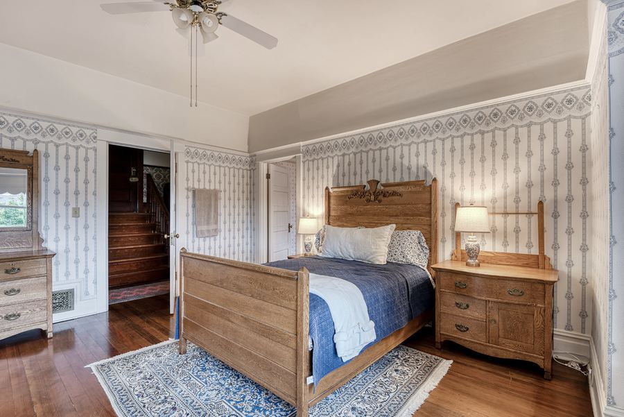 The Anglin Suite: an oak bed, dresser and pale striped wallpaper